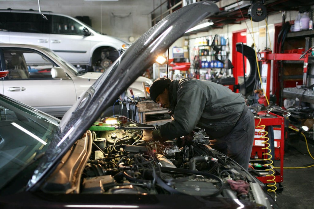 A mechanic works on a car.