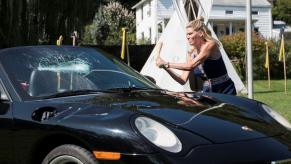 A scene from 'The Path' TV show where a woman smashes a Porsche with a baseball bat