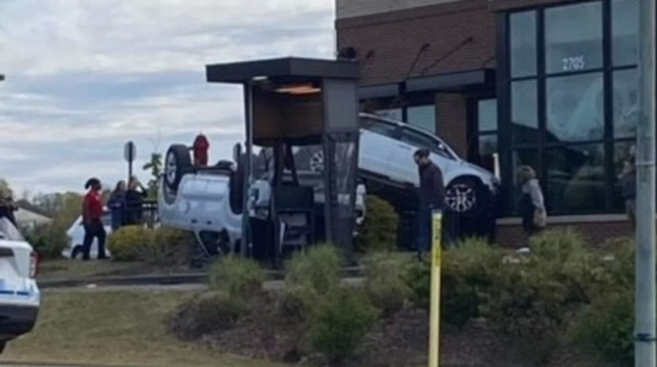 A Dodge Caliber on top of a flipped pickup truck in Chik-Fil-A drive-through