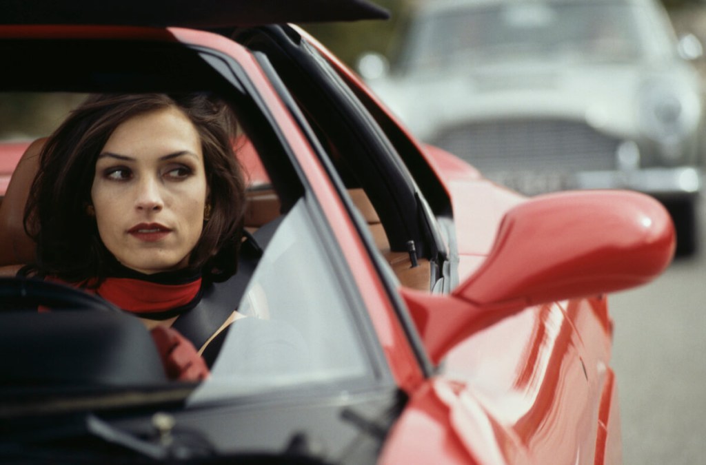 A James Bond girl drives a Ferrari