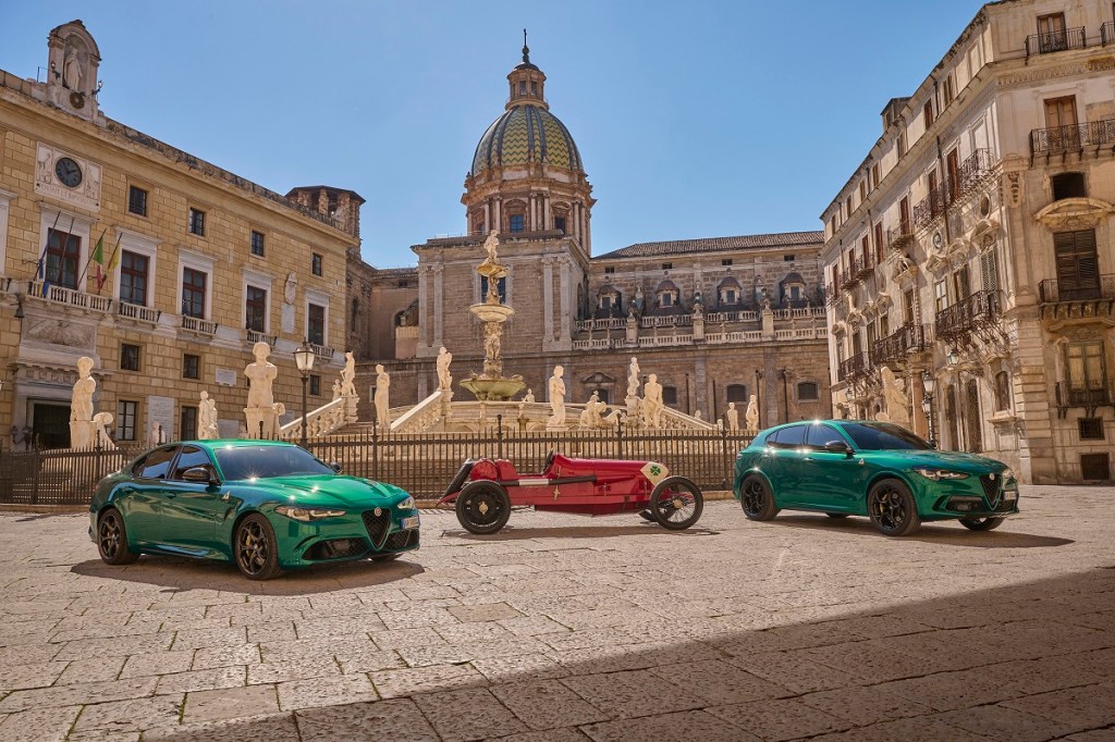 A green Alfa Romeo Giulia and Stelvio flanking a 123 Quadrifoglio race car. 
