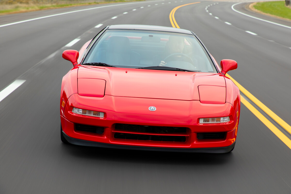 A head-on view of the 1991 Acura NSX driving down a road
