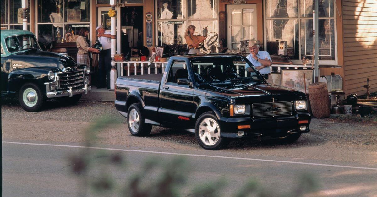 A 1991 GMC Syclone performance half-ton pickup truck model being admired by a passerby