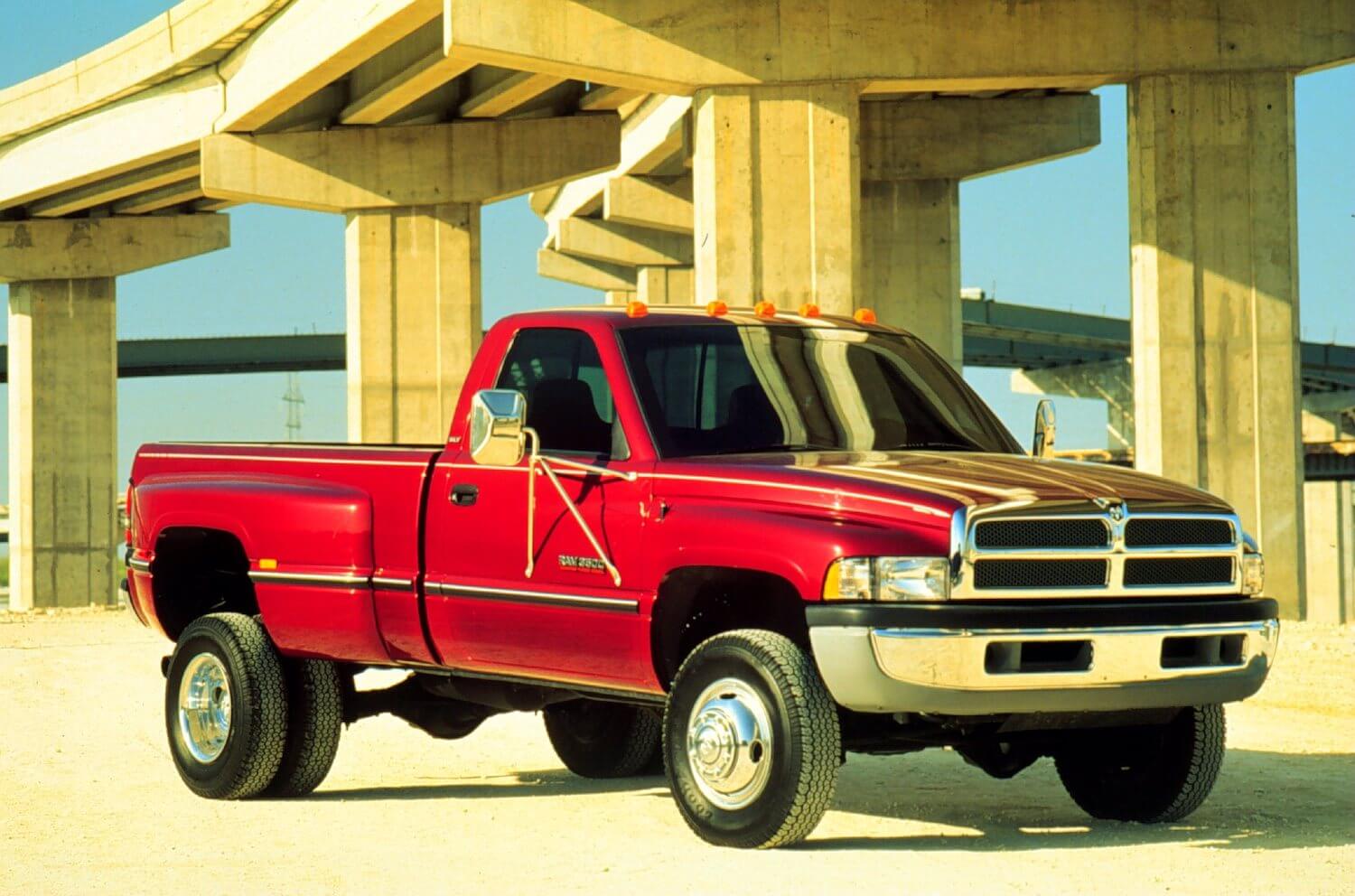 A red 1997 Dodge Ram 3500 truck with the Cummins I6 turbodiesel engine, parked under a bridge.