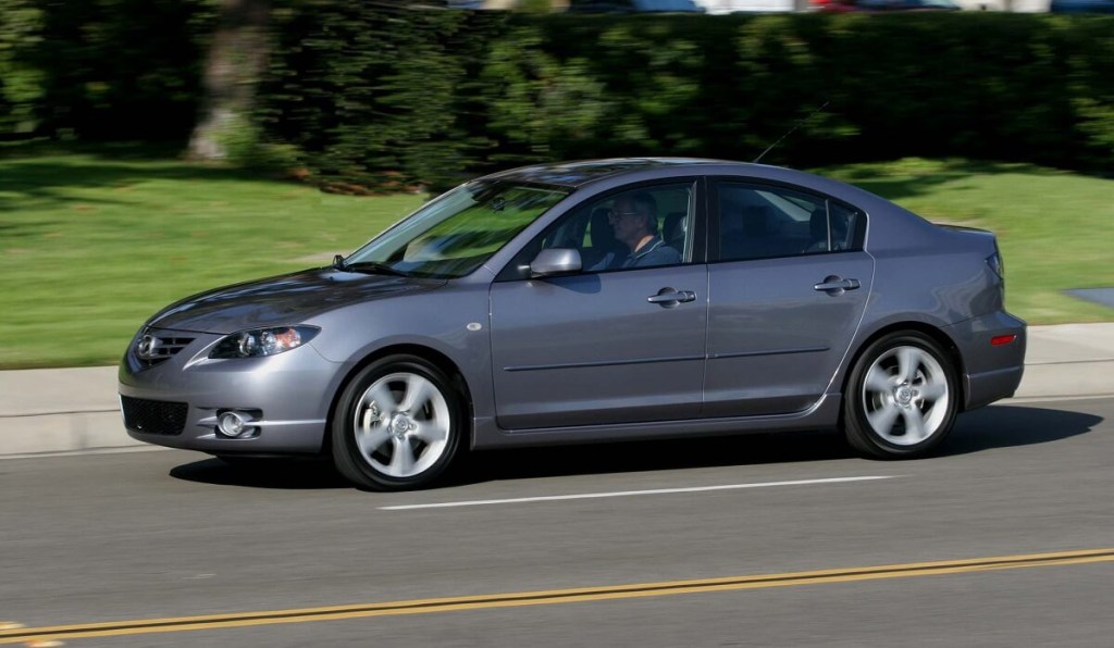 A 2006 Mazda3 cruises down a back road.