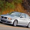 A used silver 2007 BMW 335i cruises around a hilltop.