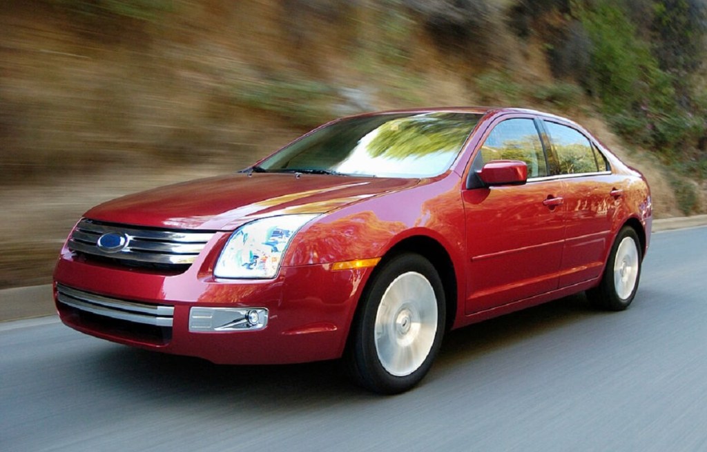 A used 2009 Ford Fusion four-door car cruises around a mountain pass. 