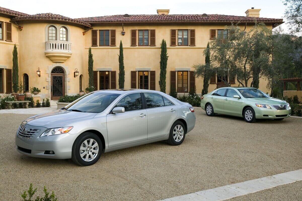 A set of used 2007 and 2008 Toyota Camry models park next to a hacienda.