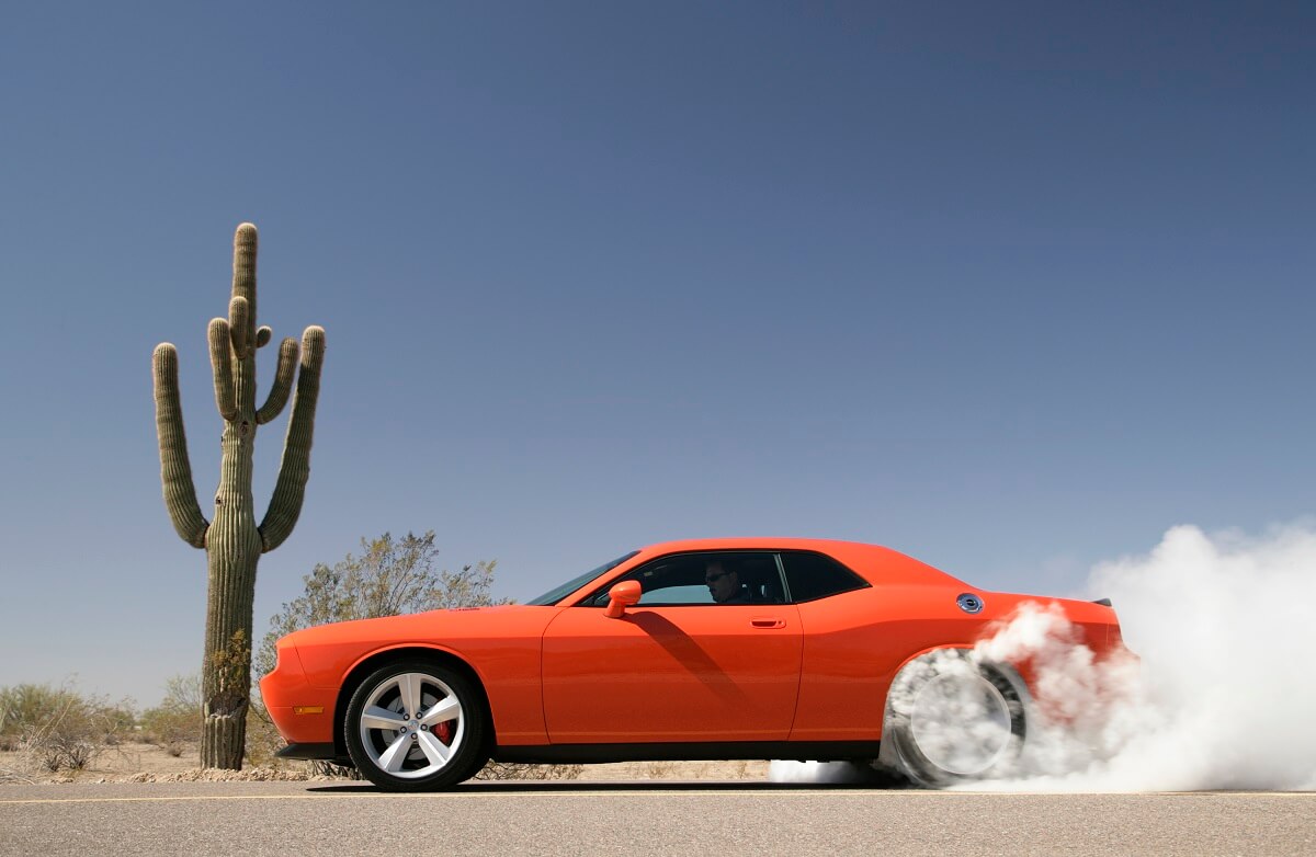 A 2010 Dodge Challenger does a burnout in the desert.