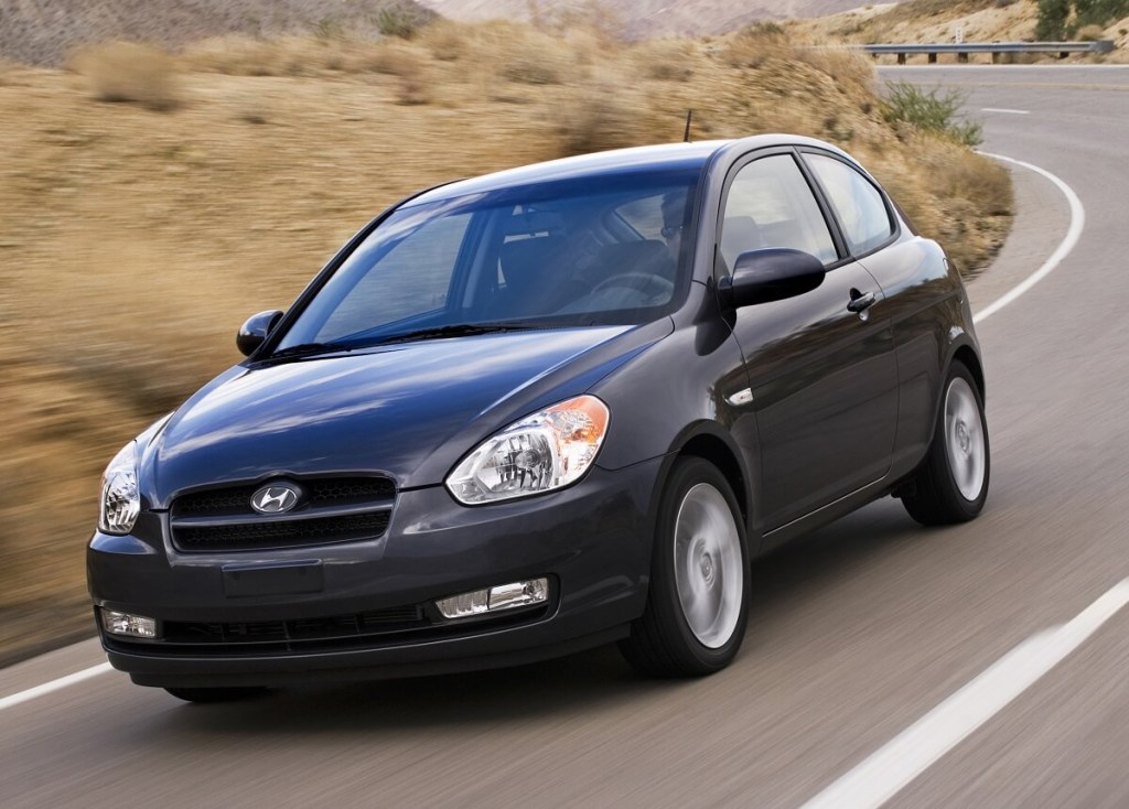 A gray 2010 Hyundai Accent shows off its small car proportions that makes it one of the best used cars on a country road. 