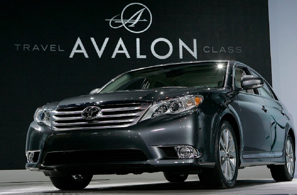 A gray 2010 Toyota Avalon sits on a stage at an auto show. 