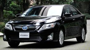 A 2011 Toyota Camry Hybrid driving down the road.