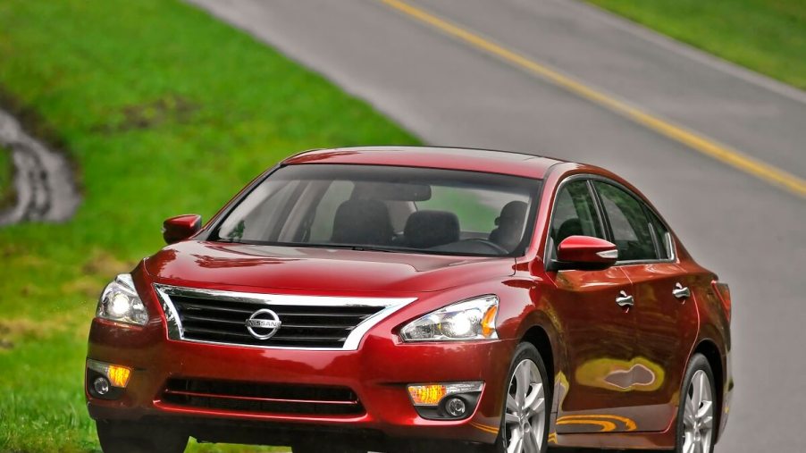 A red 2014 Nissan Altima takes a corner.