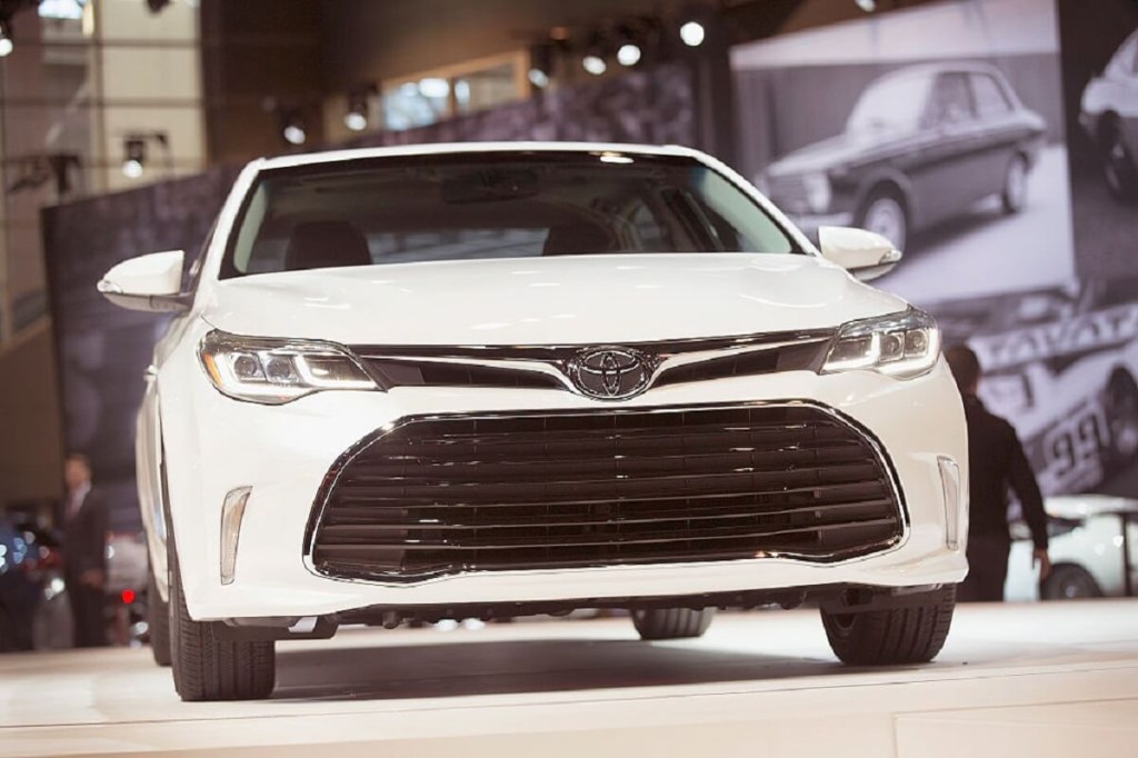 A white 2015 Toyota Avalon shows off its fascia on a stage.