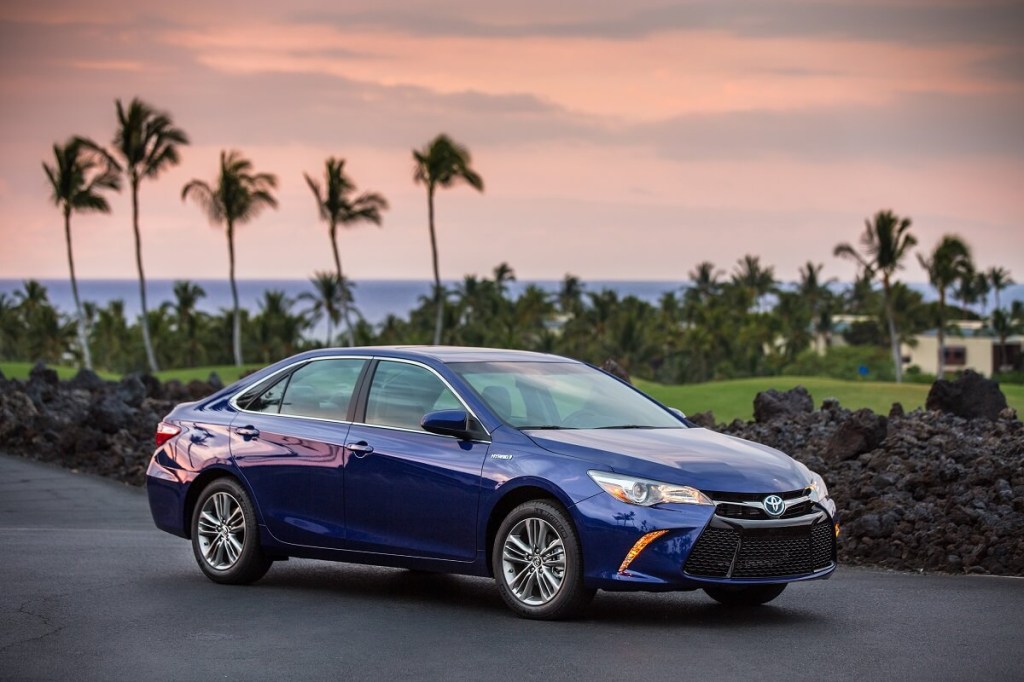 A famously reliable used 2015 Toyota Camry midsized car shows off its blue paint work. 