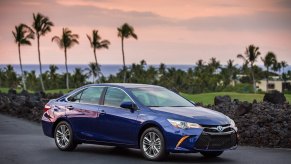 A famously reliable used 2015 Toyota Camry midsized car shows off its blue paint work.