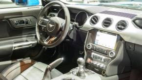 The interior, dashboard, and infotainment screen AM radio station of a Ford Mustang model in Brussels, Belgium
