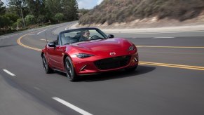 A red 2017 Mazda MX-5 driving on a road.