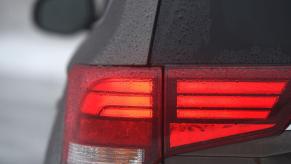 An illuminated taillight of a 2018 Mitsubishi Outlander SEL AWD compact SUV model covered in rain droplets