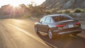 A rear view of the 2020 Audi S4 driving down the road.
