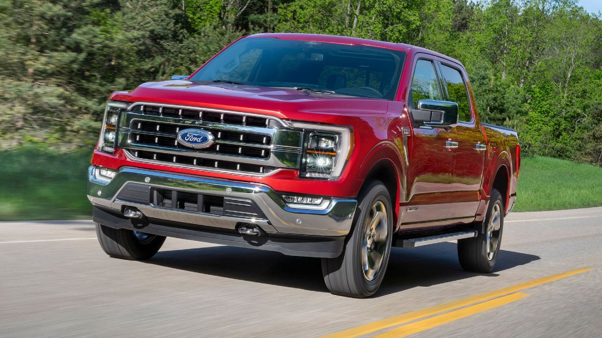Red 2021 Ford F-150 PowerBoost Hybrid Truck Driving on a Road - This is the most unreliable modern pickup truck in the market