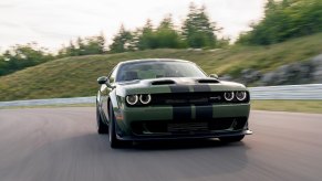 An F8 Dodge Challenger SRT Hellcat cruises on a track.