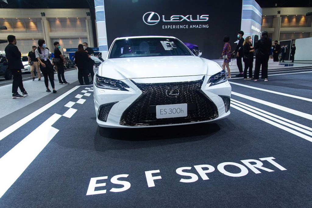 A white 2022 Lexus ES, parked on a blacktop area with ES F Sport printed on the ground, which is also one of the safest cars of 2022. 