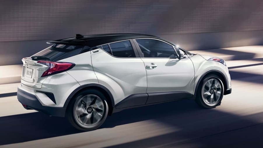 A white 2022 Toyota C-HR subcompact SUV is driving.