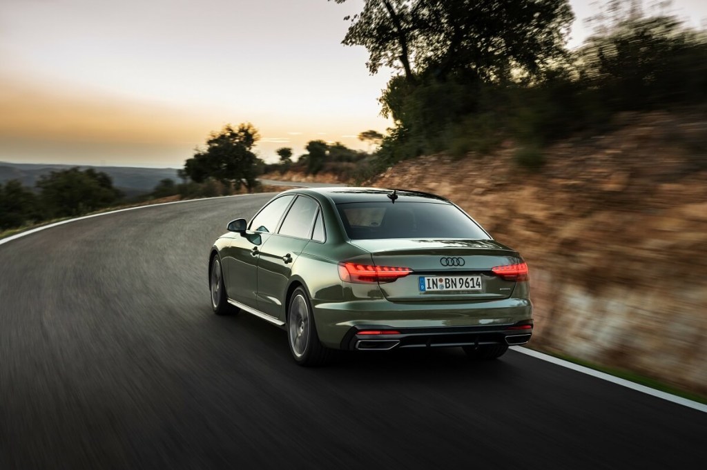 A green 2023 Audi A4 shows off the brand's platform that earned a safest luxury car spot in the segment while it takes a mountain corner. 