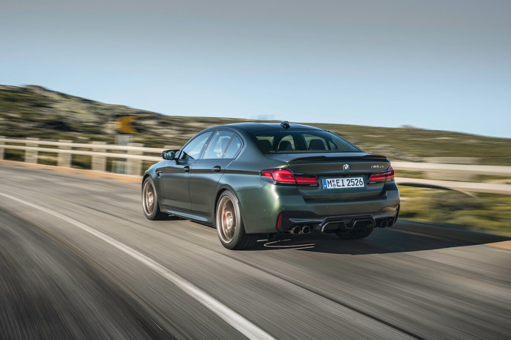 A rear view of the 2023 BMW M5 driving down the road.