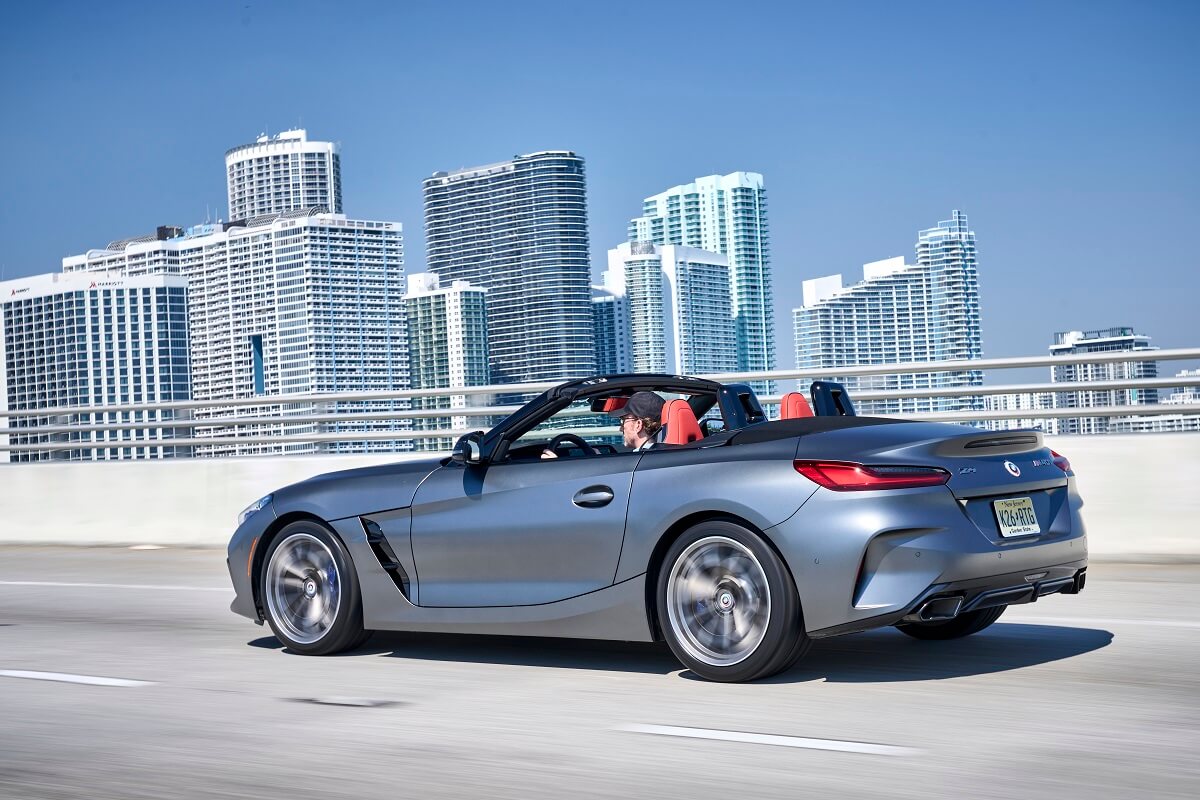 A 2023 BMW Z4 M40i luxury sports car cruise by a city skyline.