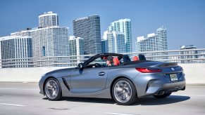 A 2023 BMW Z4 M40i luxury sports car cruise by a city skyline.