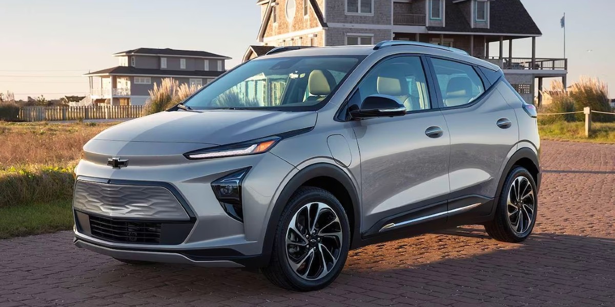 A gray 2023 Chevrolet Bolt EUV subcompact SUV is parked on the beach.