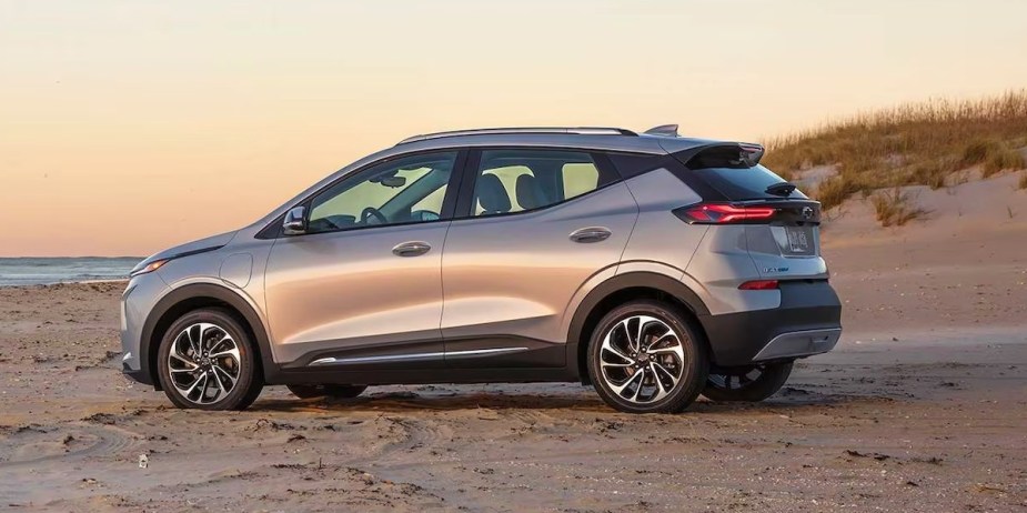 A gray 2023 Chevy Bolt EUV subcompact electric SUV is parked on the beach. 