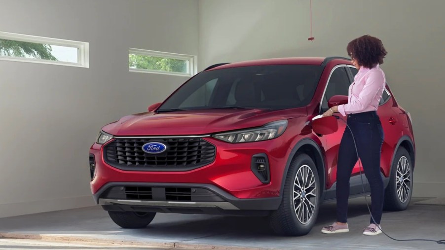 A red 2023 Ford Escape Plug-In Hybrid SUV is being charged.