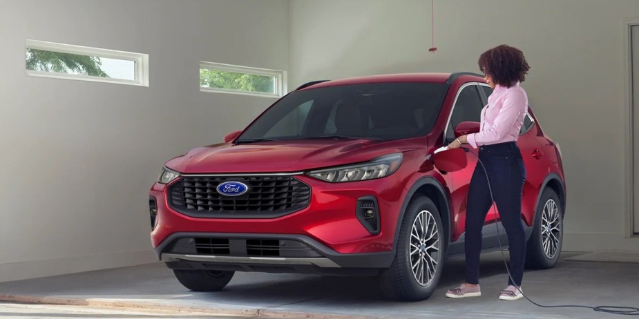 A red 2023 Ford Escape Plug-In Hybrid is charging. 
