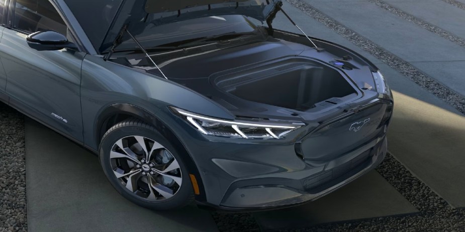 A gray 2023 Ford Mustang Mach-E small electric SUV is parked with its frunk open. 