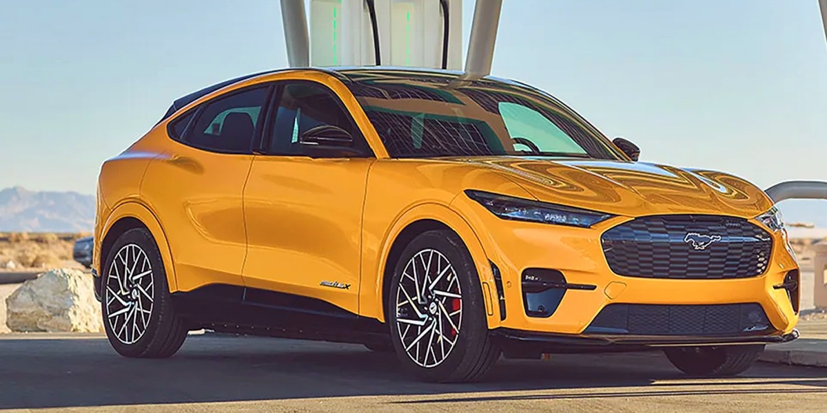 A yellow 2023 Ford Mustang Mach-E small electric SUV is parked.