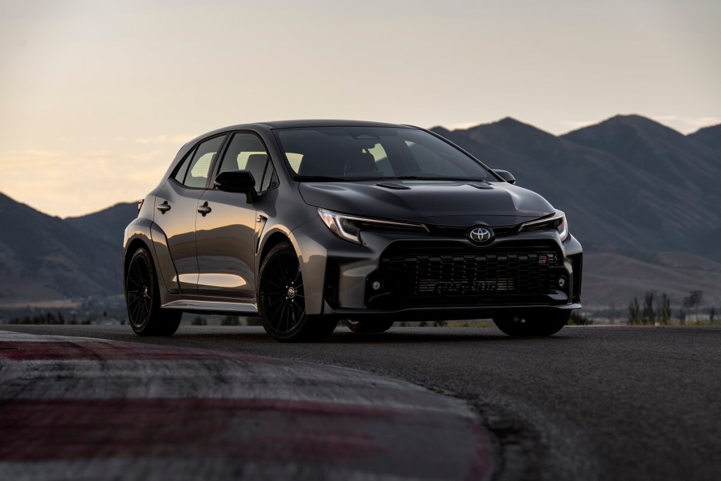 A dark gray Toyota GR Corolla hatchback shines on a test track.