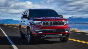 A red 2023 Jeep Wagoneer full-size SUV is driving on the road.