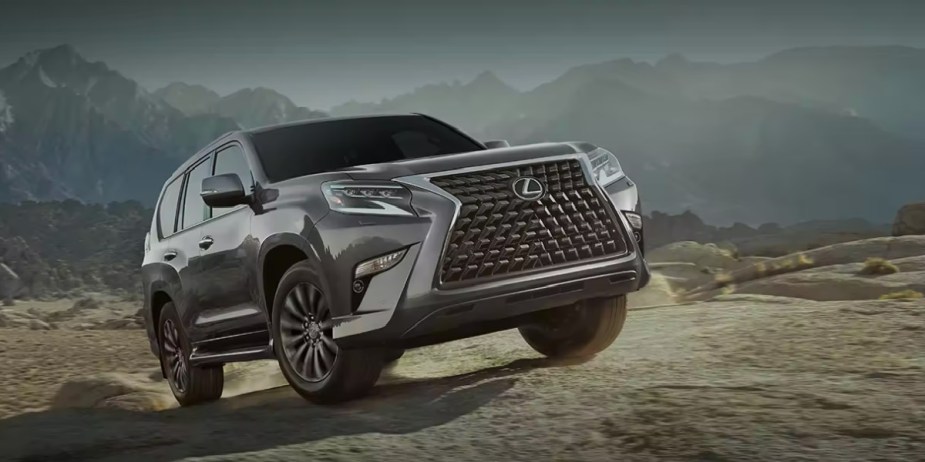 A gray 2023 Lexus GX full-size luxury SUV is driving off-road. 