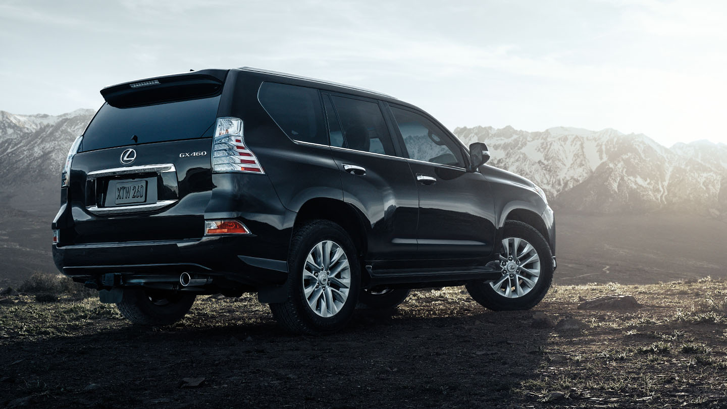 Rear view of black 2023 Lexus GX with mountains in the background. 