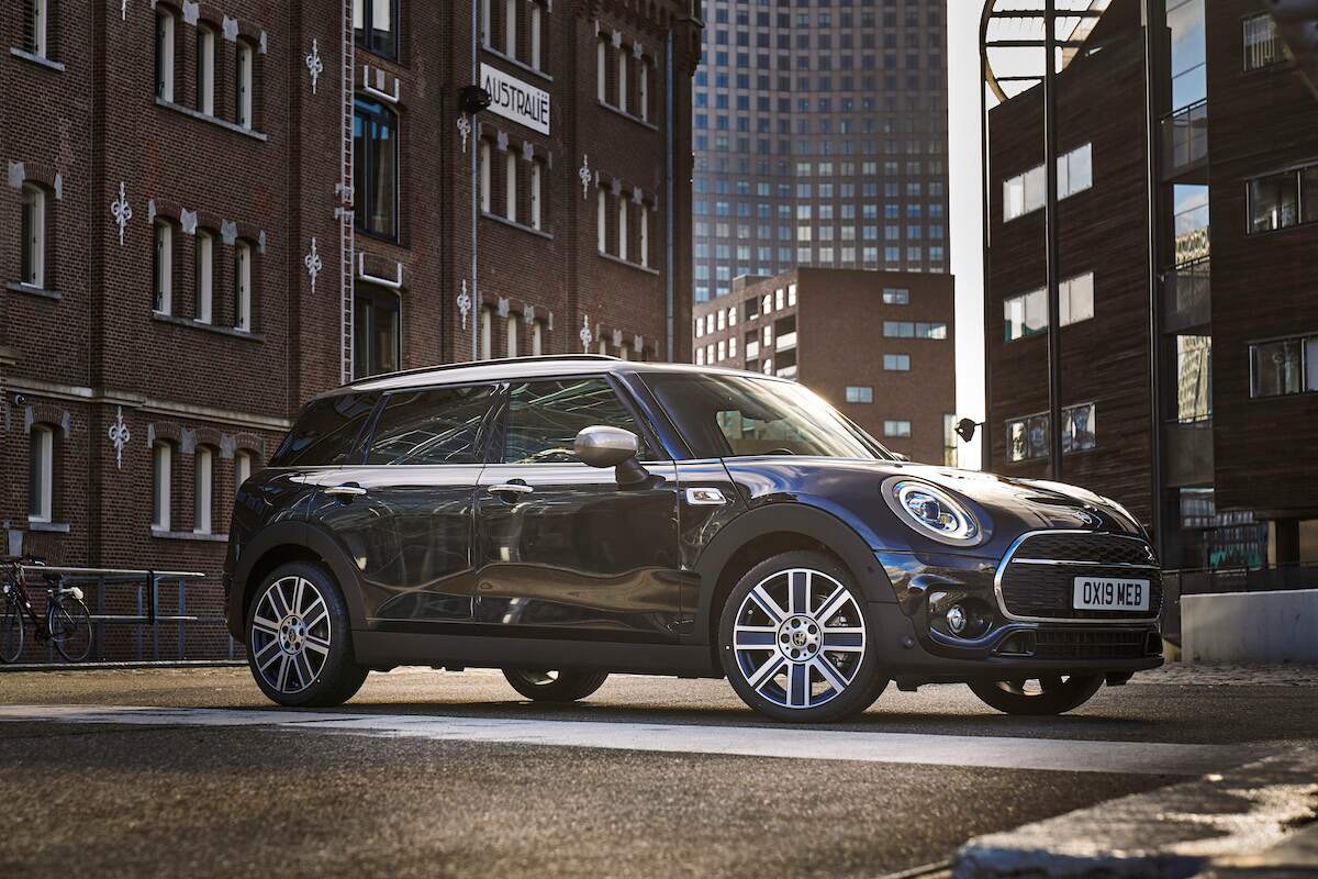 A dark color 2023 MINI Clubman parked outdoors in a city environment.