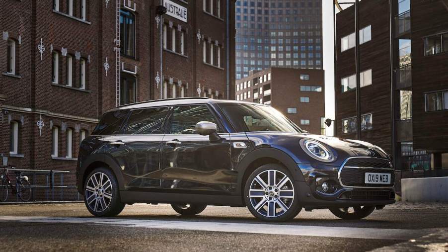 A dark color 2023 MINI Clubman parked outdoors in a city environment.