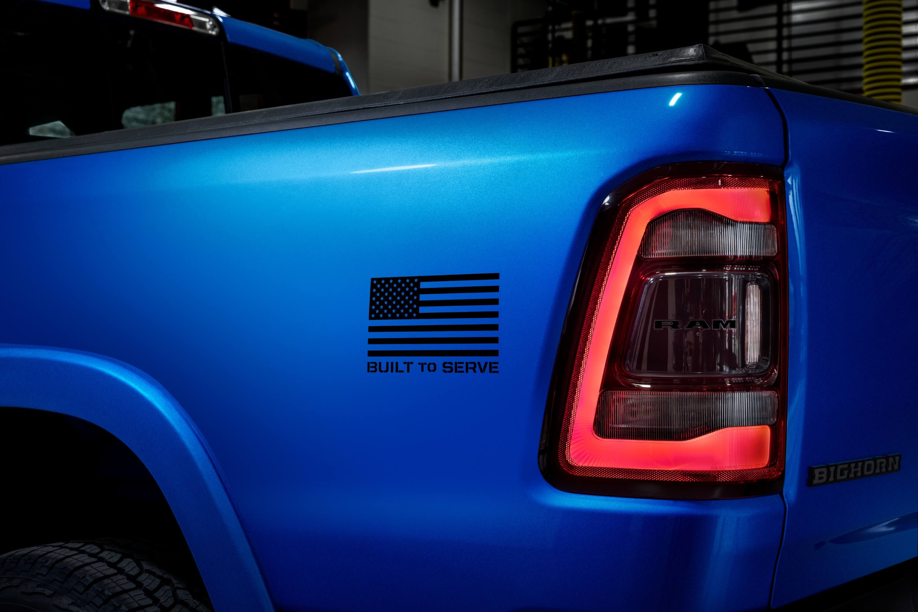 American flag painted on the blue bed of a Ram 1500 pickup truck.