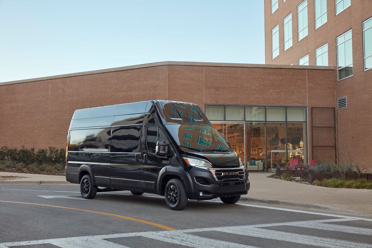 A black 2023 Ram ProMaster with a high roof commercial vehicle van model parked at a crosswalk