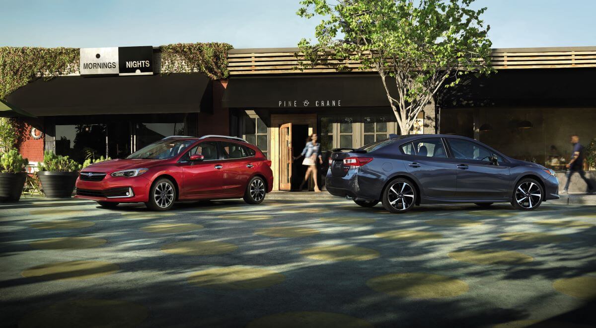 The 2023 Subaru Impreza lineup, featuring a red Impreza hatchback and a gray Impreza sedan