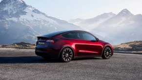 A red 2023 Tesla Model Y small electric SUV is parked.