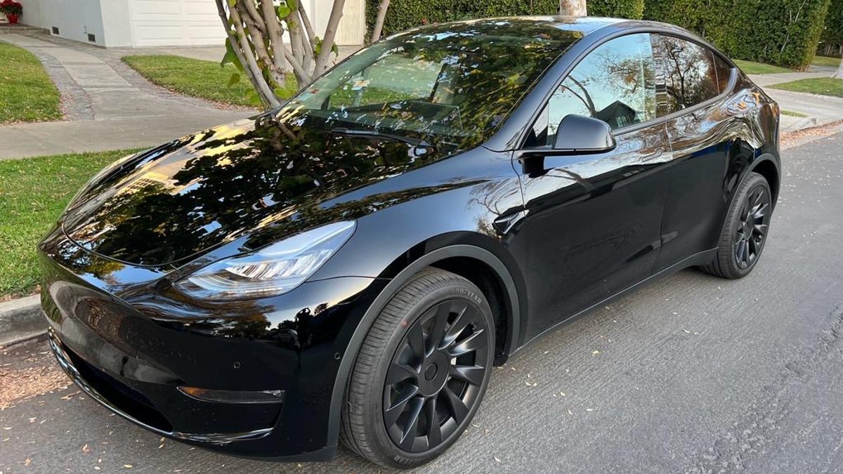 Black 2023 Tesla Model Y parked next to a curb.