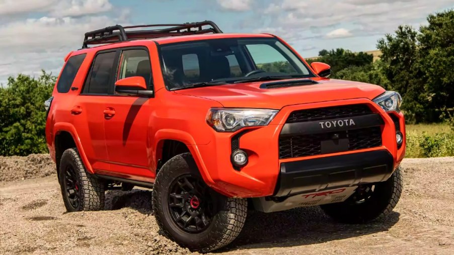 An orange 2023 Toyota 4Runner is parked off-road.